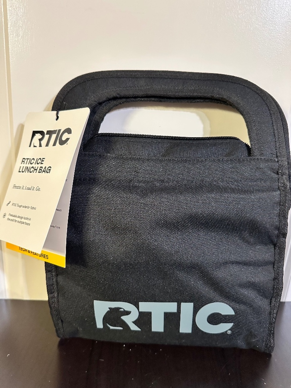 This is a black RTIC Ice Lunch Bag with a freezable, collapsible design